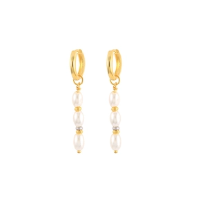 Macro detail of triple pearl drop earrings with golden beads and circular hoops