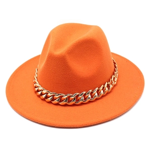 Orange wool felt fedora hat featuring a chunky gold chain strap on a white background