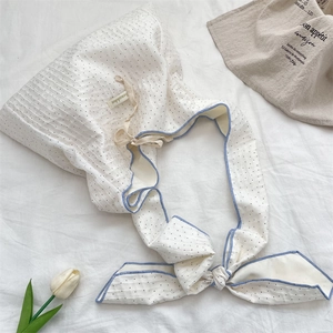 Détail du tissu en toile à pois avec bordure bleue et ruban réglable à nouer