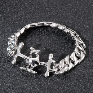 Macro shot of silver Cuban chain bracelet with molten cross detail and metal textures