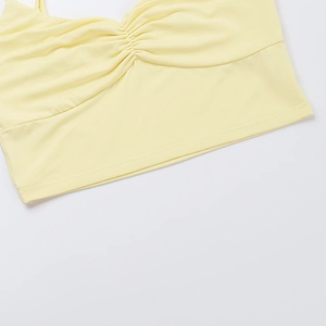 Close-up of pale yellow knit camisole featuring ruched chest design and flat hem stitching