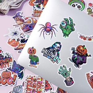 Close-up of holographic Halloween stickers with pumpkin and skull designs on laptop