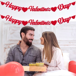 Striscione rosso Happy Valentine's Day appeso a una parete in una romantica camera da letto