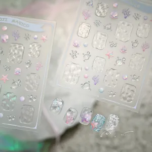 Macro detail of 3D ocean nail stickers featuring water ripples, shells and coral patterns