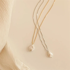 Détail de pendentifs en perles baroques sur des chaînes en or et argent minimalistes