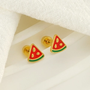 Macro shot of watermelon stud earrings with enamel details on white textured fabric