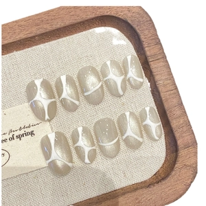 Handmade almond press-on nails with nude shimmer and white abstract marble line patterns