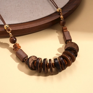 Bohemian sweater necklace with wooden beads and coconut shells on a natural background