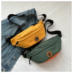 Close-up of yellow and green Oxford fabric waist bags with adjustable straps and logo detail