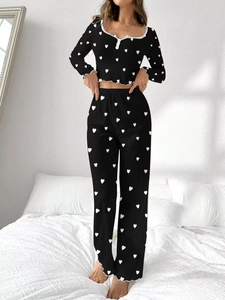 Detail of black pajama set with white heart print and ruffled lettuce trim edges