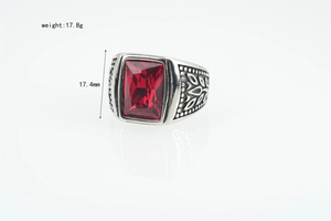 Macro shot of vintage titanium steel ring with red gemstone and engraved details