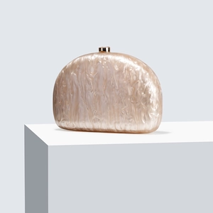 Close-up of semi-circular acrylic evening clutch with pearl marble texture and gold clasp