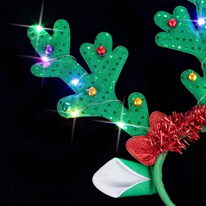 Macro view of glowing LED reindeer antlers headband with green sequins and colorful bells