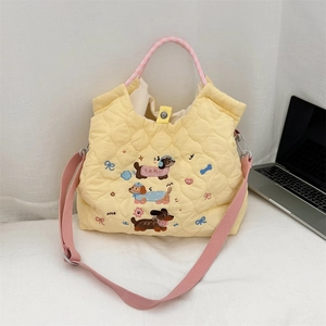 Detail of cartoon dachshund embroidery on yellow quilted puffer tote bag with pink strap