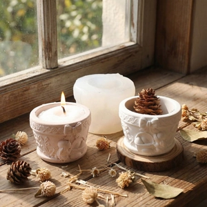 Detail of silicone mold and finished plaster bowls with relief bow and rabbit patterns