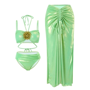Detail of mint green metallic bikini set with sun-shaped rhinestone brooch and sarong
