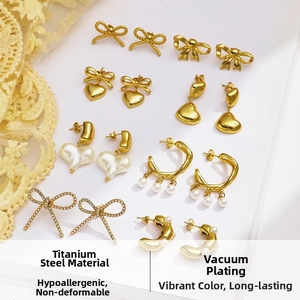 Detailed flat lay of gold-plated titanium steel earrings featuring bow and heart motifs