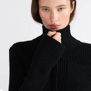 Close-up of black ribbed knit sweater featuring a stand collar and metal zipper detail