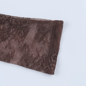 Macro detail of dark brown lace fabric with intricate floral embroidery and mesh texture