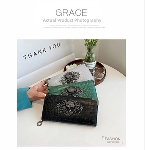 Close-up of elegant crocodile pattern clutch wallets with vintage skull hardware