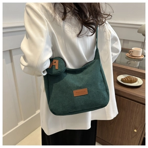Detail of dark green corduroy tote bag with removable letter A charm and fashion label
