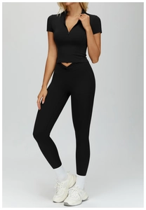 Detail of black seamless yoga set showing short sleeve zipper top and high waist leggings