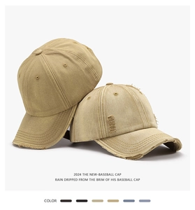 Detail of washed cotton baseball caps showing distressed holes and metal buckle closure