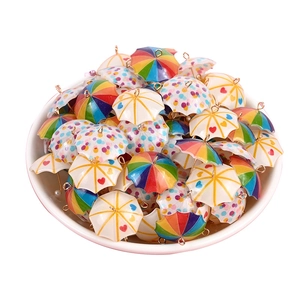 Miniature colorful umbrella charms for DIY jewelry making displayed in a white bowl