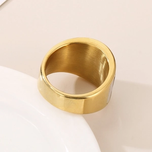 Detailed view of the wide golden stainless steel ring with brushed interior texture
