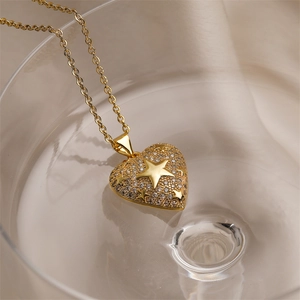 Vue artistique du pendentif cœur doré avec motifs étoiles et cristaux sur un verre d'eau
