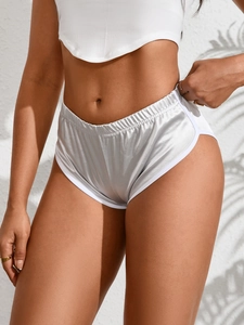 Dettaglio degli shorts sportivi in raso argento con bordo bianco e vita elastica
