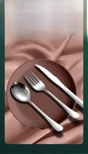 Polished stainless steel cutlery set with mirror finish on dark plate and pink silk