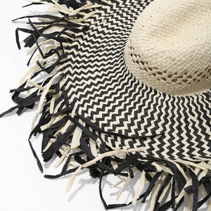 Detail of chevron weave pattern and frayed edges on a wide-brim straw beach hat