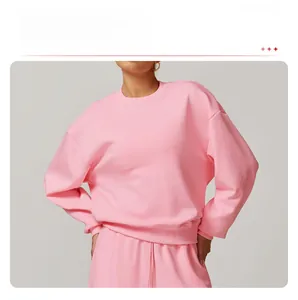 Détail du sweat à col rond rose avec poignets côtelés et texture en coton doux