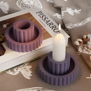 Detail showing two-piece purple gear-edged candle tray with burning pillar candle