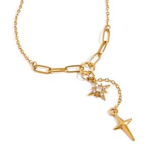 Détails des pendentifs étoile et croix dorés en Y sur un collier trombone en acier