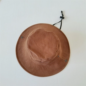Detailed top view of a brown outdoor sun hat with adjustable wind rope and metal side snaps