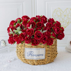 Detail of deep red artificial roses in a round woven flower basket for home decoration
