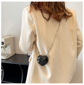 Mini black heart-shaped crossbody bag with diamond-cut shell and silver chain strap