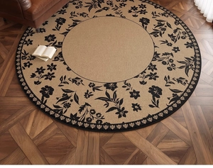 Close-up of vintage floral round rug with black branch patterns on woven beige fabric