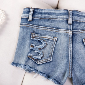 Dettaglio degli hot pants in denim blu con tasche posteriori e orlo a vivo