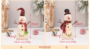 Detail of linen snowman plush dolls with stick arms and festive scarves in a winter setting