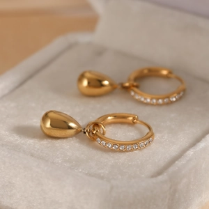 Gold-plated hoop earrings with teardrop zircon pendants in a velvet jewelry box