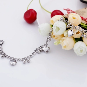 Polished heart charm and bead details on a silver stainless steel chain bracelet