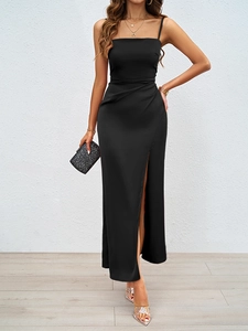 Détail d'une robe mi-longue en satin noir avec fente latérale haute et fronces élégantes