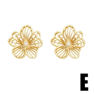 Detailed close-up of gold-plated hollow flower earrings with white zircon center