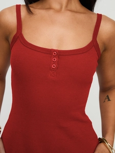 Gros plan sur un caraco en maille côtelée rouge avec détail de décolleté Henley boutonné