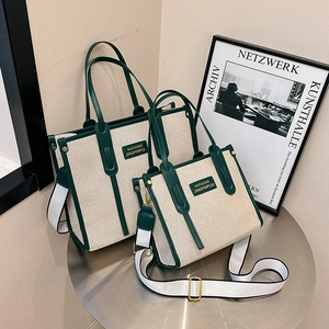 Minimalist beige canvas tote bag with green leather trim in large and small sizes