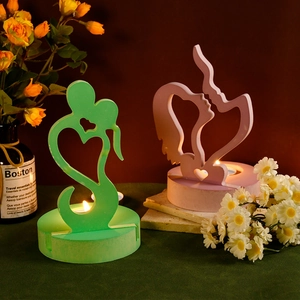 Detailed view of heart-shaped silhouette candle holders in pink and green resin