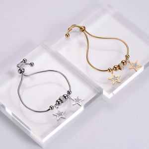 Close-up of adjustable star charm bracelets on acrylic stands with crystal details